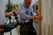 man installing timber picket fencing