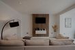 minimalist cream-coloured lounge with wall mounted tv